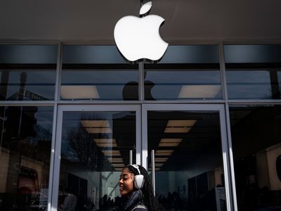 Someone walking in front of an Apple store.