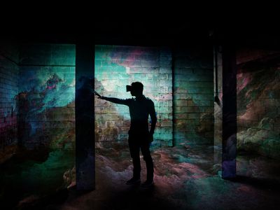 Guy interact with virtual reality headsets inside a decay and dark warehouse transported to a different and colorful new dimension