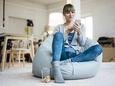 Woman using cell phone in house