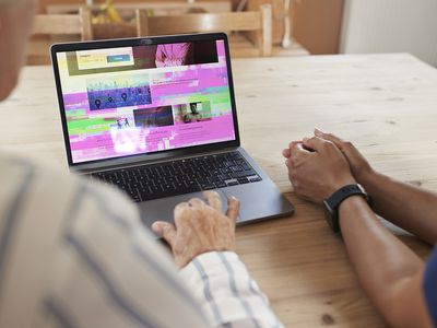 A computer laptop with vertical and horizontal lines and static on its monitor screen.