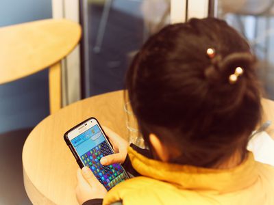 A kid playing Candy Crush on a Samsung phone.