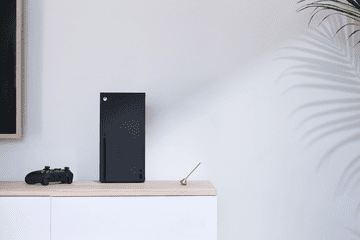 The Xbox Series X resting on a table against a white wall